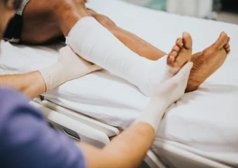 Persona con fractura ósea en el brazo inmovilizado tras un posible traumatismo.