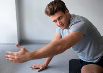 Persona realizando rotaciones externas con banda elástica para fortalecer el manguito rotador.