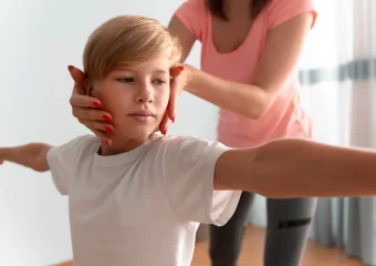 Niño en consulta médica siendo examinado por un ortopedista para detectar escoliosis.